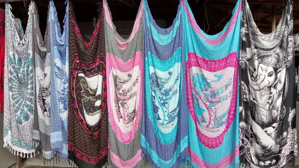 Printed beach sarongs hanging in rows at a Bali market stall