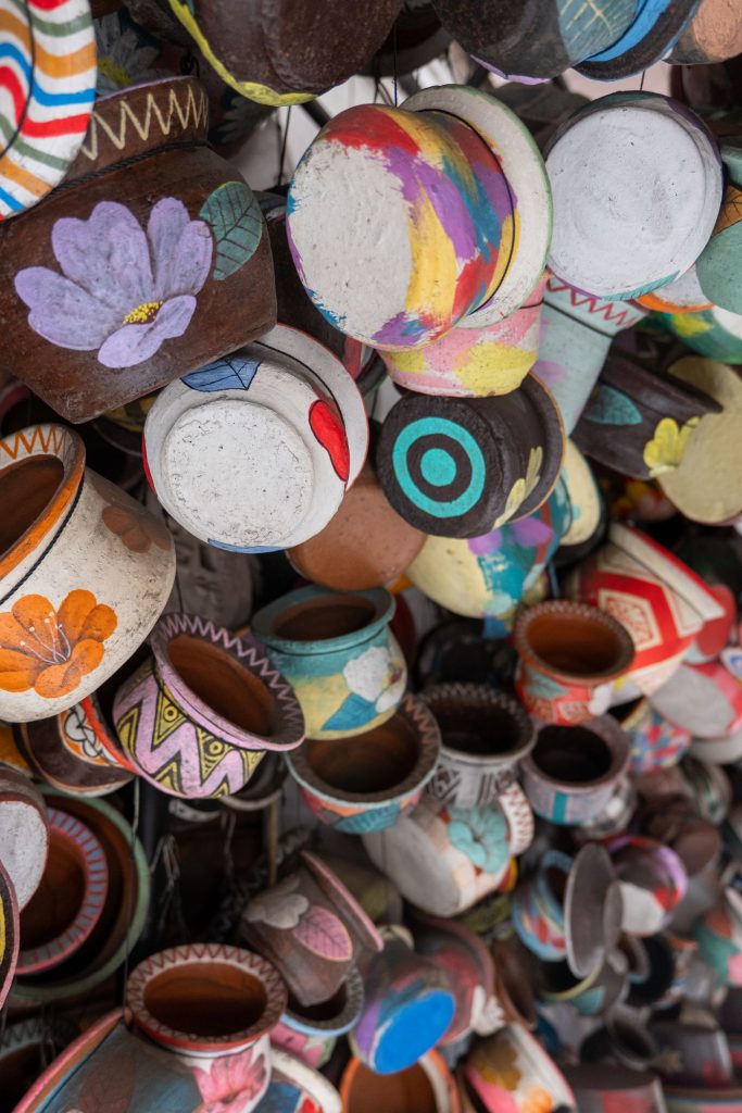Bowls and cups in mixed glazes stacked on a market pottery stall