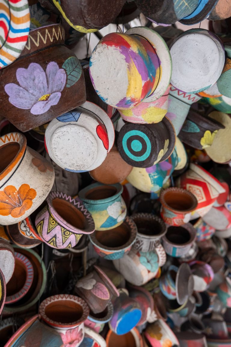 Bowls and cups in mixed glazes stacked on a market pottery stall