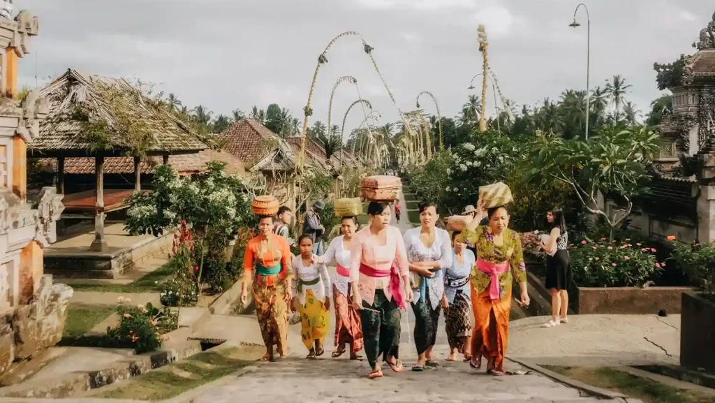 Women carrying temple offerings through Penglipuran village