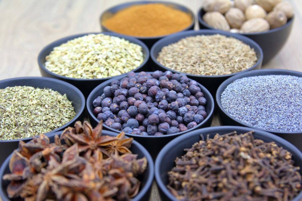 Small bowls of star anise, peppercorns, cloves and seeds arranged together