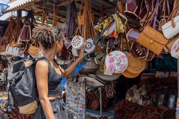 Woven rattan bags and embroidered pouches at an Ubud artisan stall