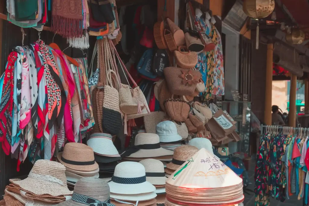 Straw hats, printed scarves and woven rattan bags filling a souvenir stall in Ubud